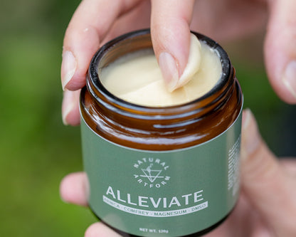 woman's hand using the ALLEVIATE topical pain relief cream. Soft offwhite color, smooth texture, easy to apply